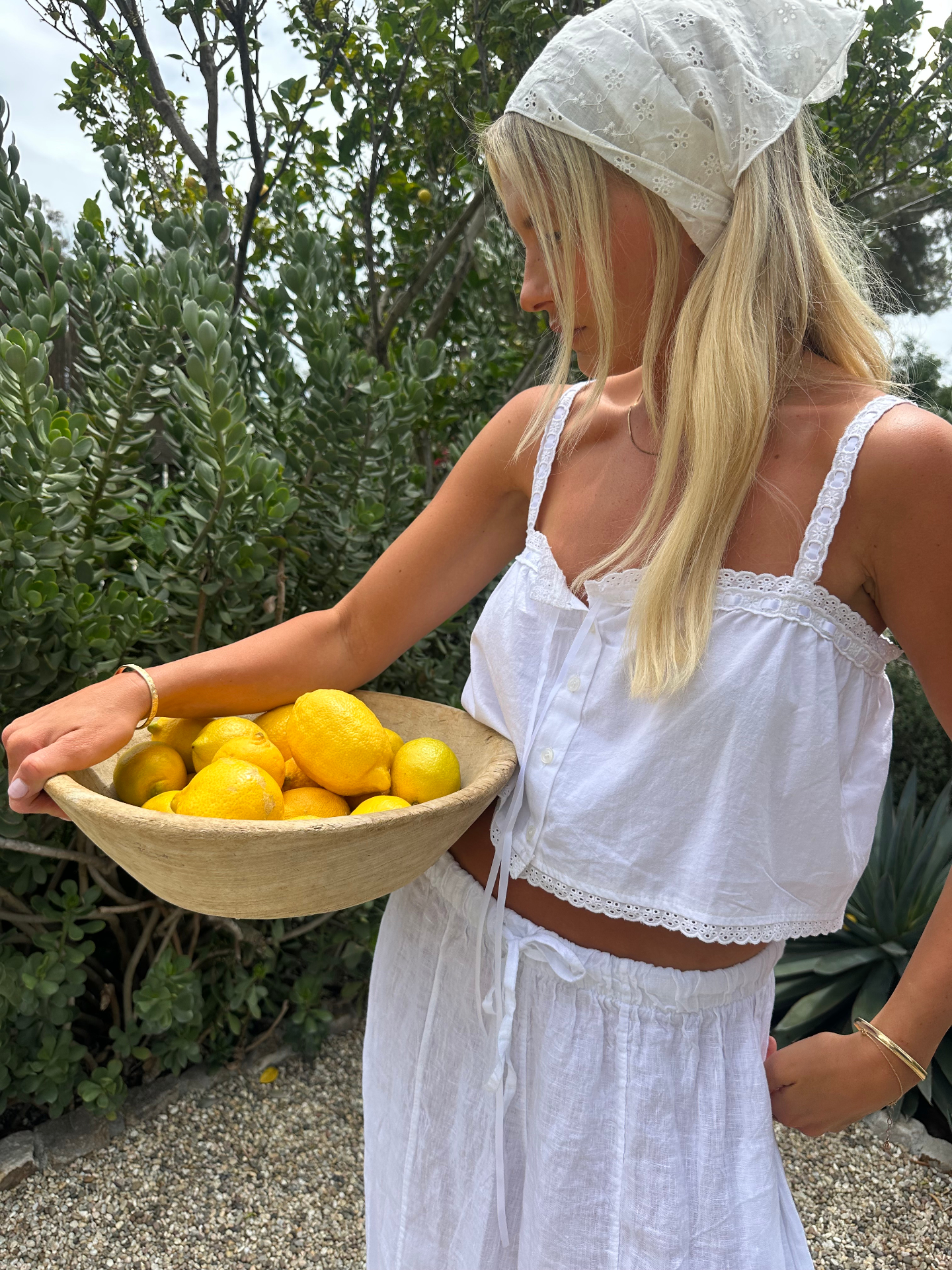 Karlie Dempsey holding a bowl of lemons in a coastal garden